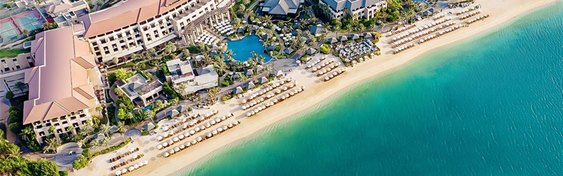 Marco Polo - Sofitel The Palm Resort & Spa - Exteriér luxusního hotelu Sofitel The Palm Resort & Spa v Dubaji na ostrově Palm Jumeirah s tropickou zahradou, palmami a bazénovou lagunou.