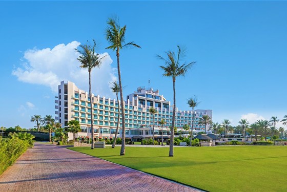 Marco Polo - JA The Resort JA Beach Hotel - Exteriér hotelu JA Beach Hotel v resortu JA The Resort v oblasti Jebel Ali v Dubaji s tropickou zahradou a bazénem.