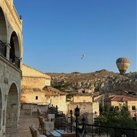 Dedeli Konak Cave Hotel - Terasa hotelu Dedeli Konak Cave s výhledem na skalní krajinu Kapadokie a ranní balóny nad údolím. - www.marco-polo.cz