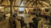 Vlci v mlze | prémiové safari u Hudsonova zálivu - Společenský prostor Nanuk Polar Bear Lodge ukazuje komfortní stránku prémiového safari u Hudsonova zálivu. Po dnech v zimní krajině zde hosté odpočívají, sdílejí zážitky, sledují prezentace a připravují se na další výpravy. Foto: Churchill Wild | Jad Davenport