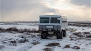 Tundra Buggy Lodge s Městem a Polárnimi Medvědy - Tundra Buggy® v tundře při západu slunce dokresluje atmosféru podzimního Churchillu. Po dnech strávených v krajině ledních medvědů se tundra mění se světlem a vytváří silné fotografické momenty.