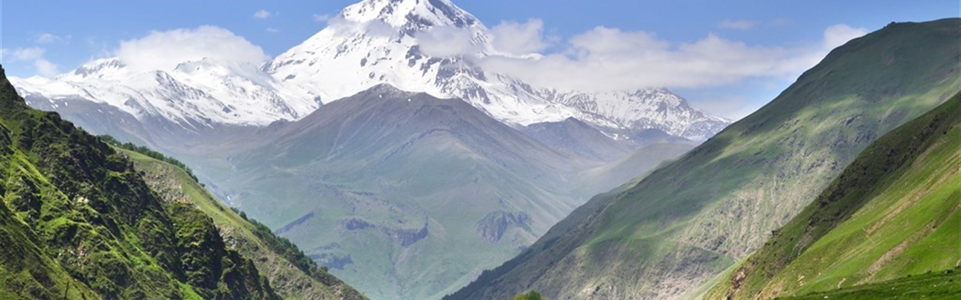 Gruzie s turistikou nejen po Kavkazu - Hora Kazbek se sněžnou čepicí s kravami pasoucími se v zeleném údolí Sno, Gruzie