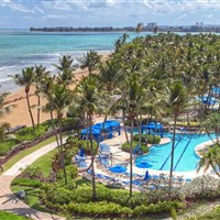 Wyndham Grand Rio Mar - Pohled na Wyndham Grand Rio Mar Rainforest Beach and Golf Resort s pláží, palmami a bazénovým areálem v oblasti Río Grande v Portoriku. - www.marco-polo.cz