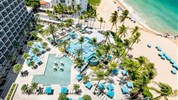 San Juan Marriott Resort & Stellaris Casino - Pohled na San Juan Marriott Resort & Stellaris Casino s bazénovým areálem, palmami a polohou u pláže Condado Beach v San Juanu.