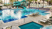 San Juan Marriott Resort & Stellaris Casino - Bazénový areál hotelu San Juan Marriott Resort & Stellaris Casino se skluzavkou a lehátky v tropické zahradě.