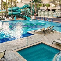 San Juan Marriott Resort & Stellaris Casino - Bazénový areál hotelu San Juan Marriott Resort & Stellaris Casino se skluzavkou a lehátky v tropické zahradě. - www.marco-polo.cz